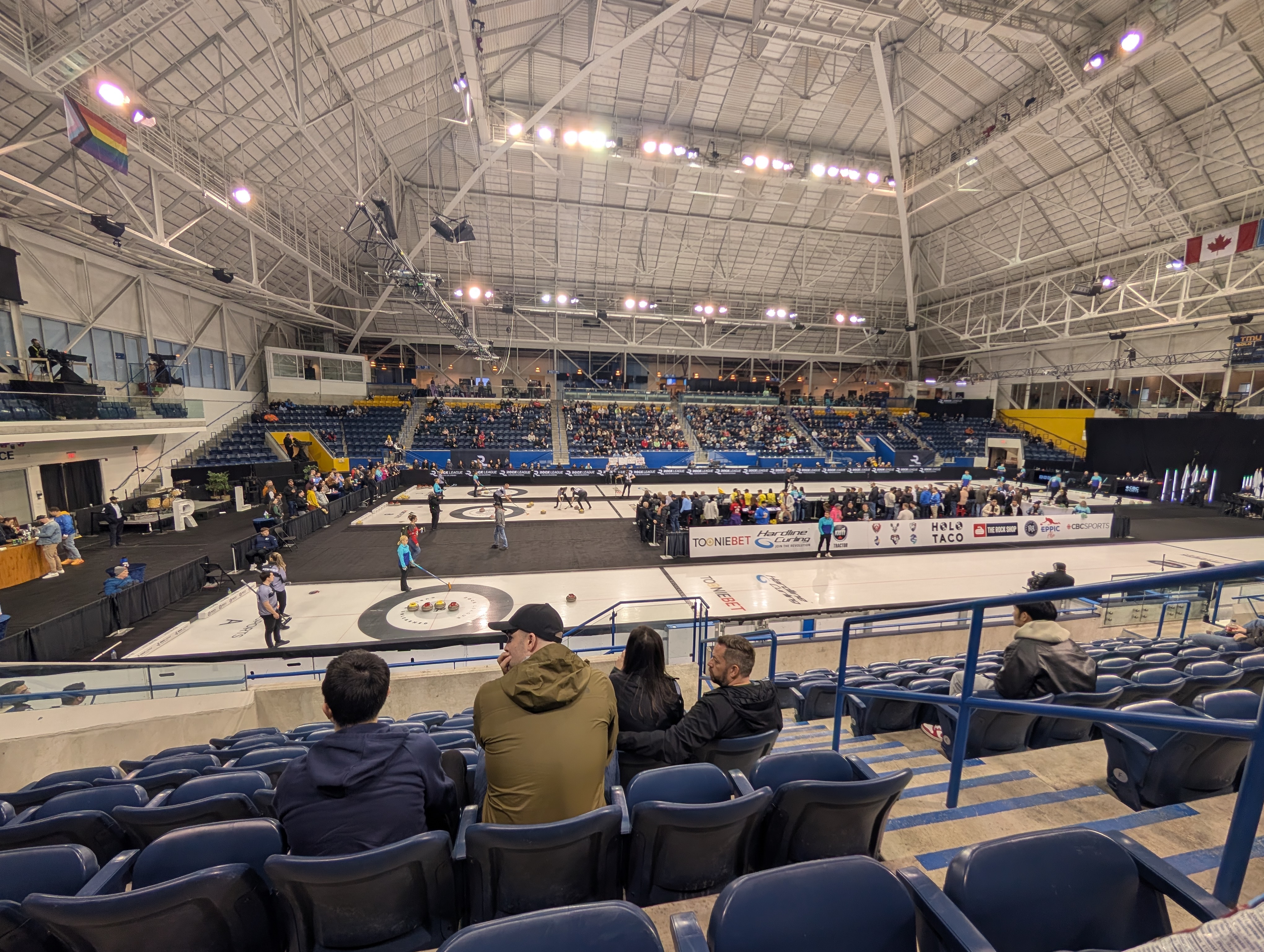 Three curling matches in progress in a university athletics stadium
