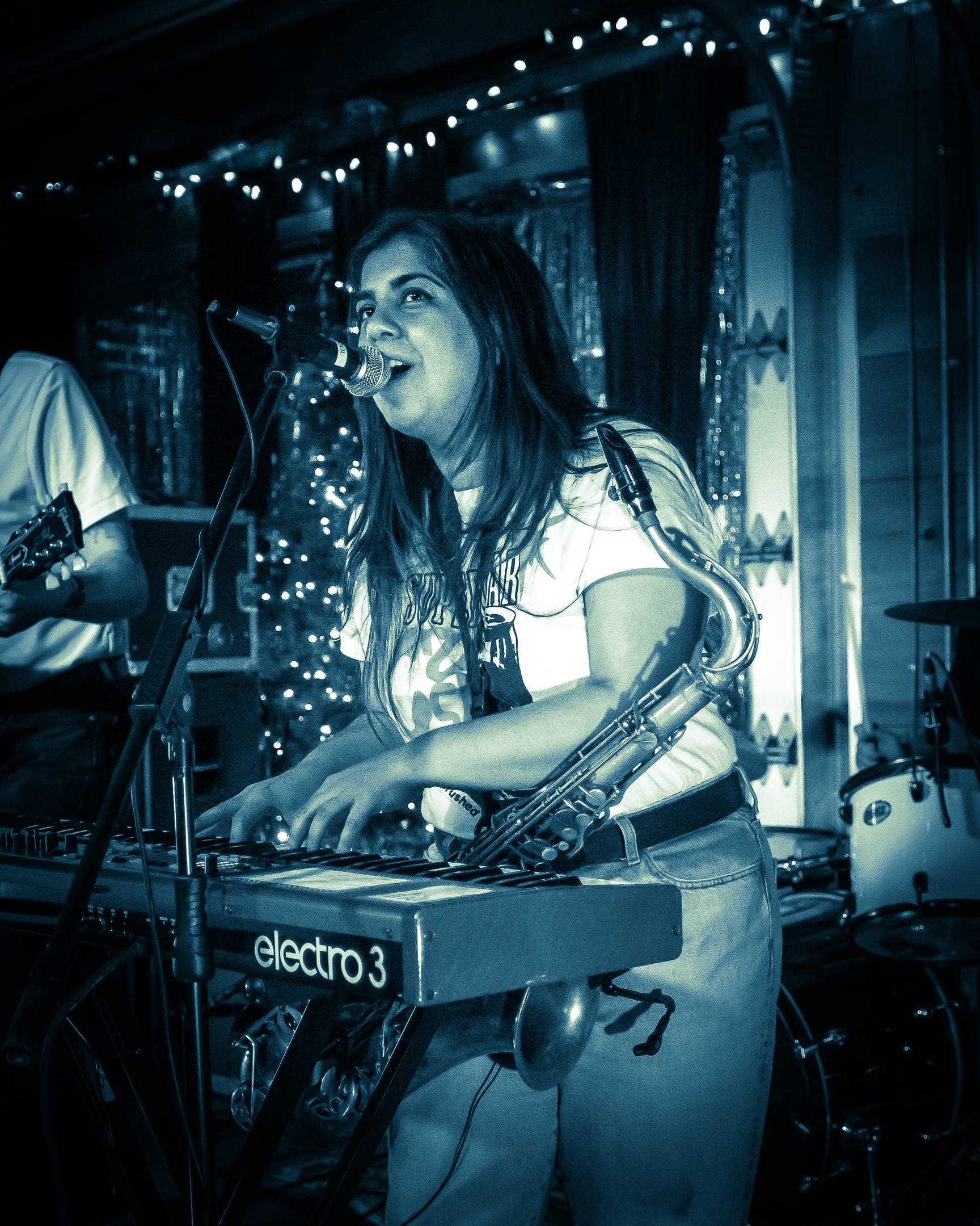 Me playing keyboard and singing with a sax hanging from my neck